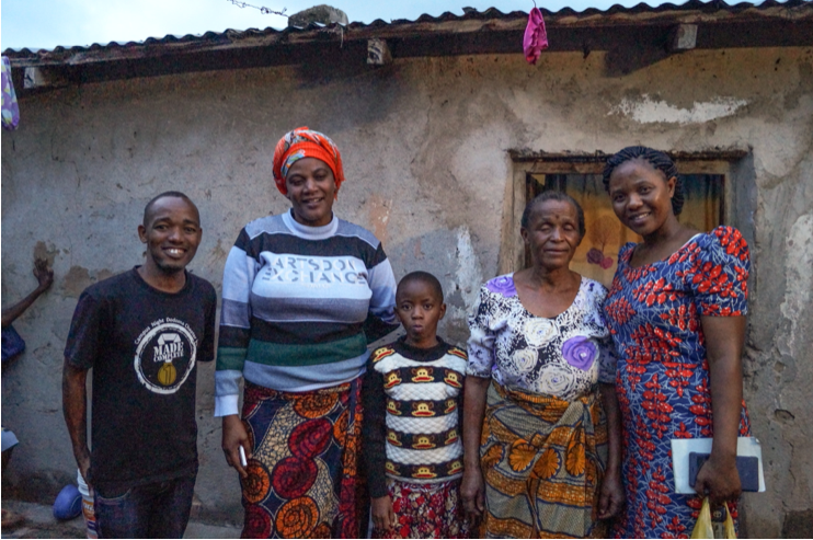 Glad afrikansk familj framför hus