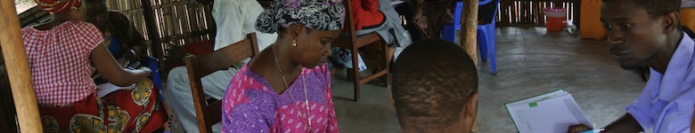 Afrikanska männikskor i hydda läser och diskuterar